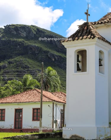 Torre sineira da Capela de Santana com montanhas ao fundo em Chapada, Ouro Preto MG