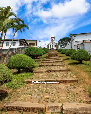 Escadaria famosa de Serro, com arbustos ao lado e a Igreja de Santa Rita no final