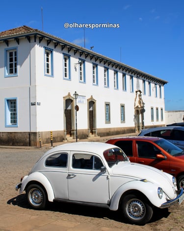 Fusca no centro histórico de Congonhas com construção historica ao fundo