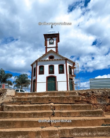 Fachada da Igreja de Santa Rita no alto do escadão de pedra, sob o céu azul no Serro