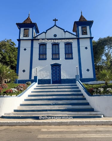 Igreja histórica em Ipoema MG com fachada azul, escadaria e jardim florido