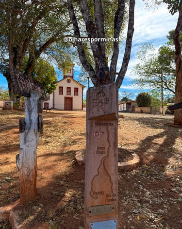 Marco da Estrada Real com igreja colonial e historica ao fundo em São Gonçalo do Rio das Pedras MG