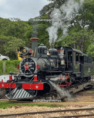 Locomotiva Maria Fumaça em Tiradentes com vapor saindo da chaminé e trilhos ao fundo