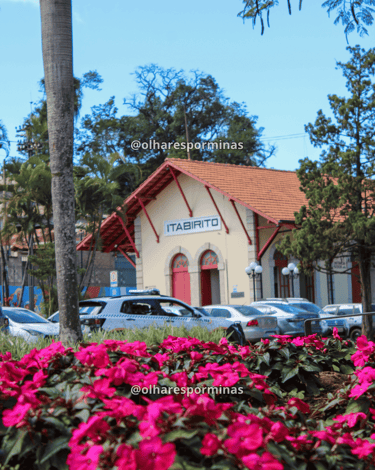 Estação ferroviária de Itabirito MG vista entre flores coloridas e palmeiras