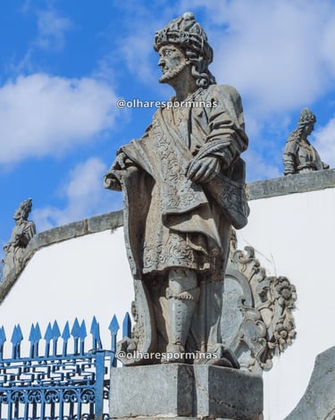 Escultura de profeta no Santuário do Bom Jesus de Matosinhos em Congonhas, sob céu azul