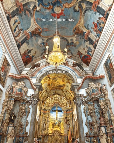 Interior do Santuário do Bom Jesus de Matosinhos em Congonhas, com altar dourado e pinturas no teto.