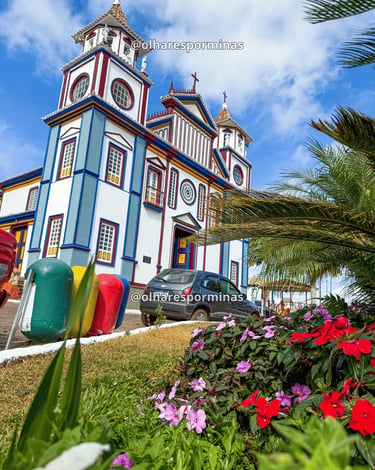 Fachada lateral da igreja de Datas MG com jardim florido e arquitetura histórica