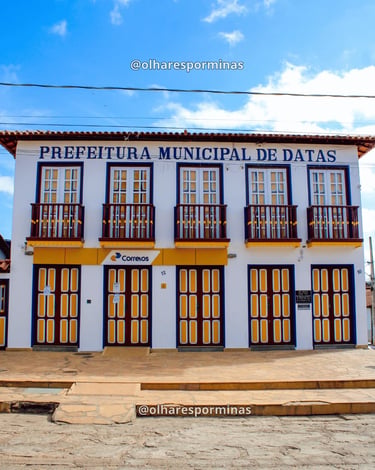 Prédio da Prefeitura Municipal de Datas MG com janelas coloniais e fachada preservada