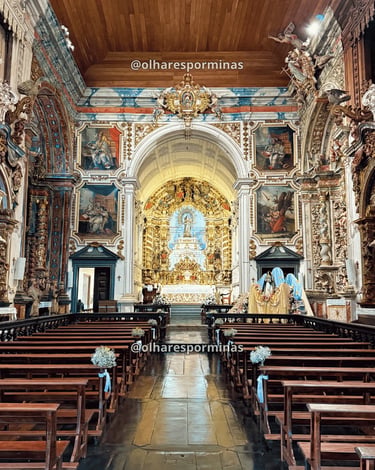 Interior da Igreja Matriz de Catas Altas MG com altar dourado, bancos de madeira, arte sacra barroca