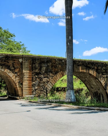 Pontilhão do Imperador em Alfredo Vasconcelos com arcos de pedra e céu azul em dia ensolarado
