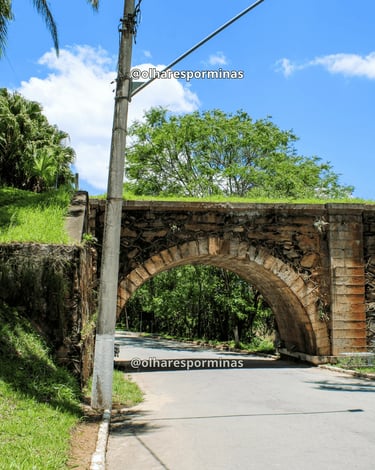 Pontilhão do Imperador em Alfredo Vasconcelos com arcos de pedra e céu azul em dia ensolarado
