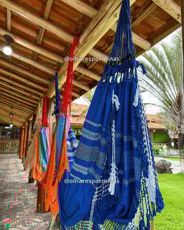 Redes artesanais coloridas em varanda de hospedagem ou espaço de descanso em Resende Costa