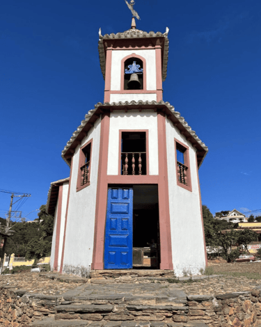 Vista externar da Capela de Nossa Senhora do Ó com céu azul em Sabará MG