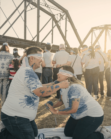 two people playing outdoor paint game blindfolded