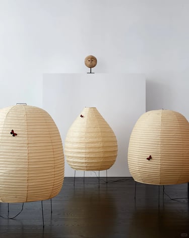 Group of glowing Akari paper lamps showing Isamu Noguchi’s soft light and organic sculptural forms