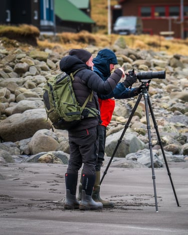 Landscape photographer at work in winter conditions, Faroe Islands