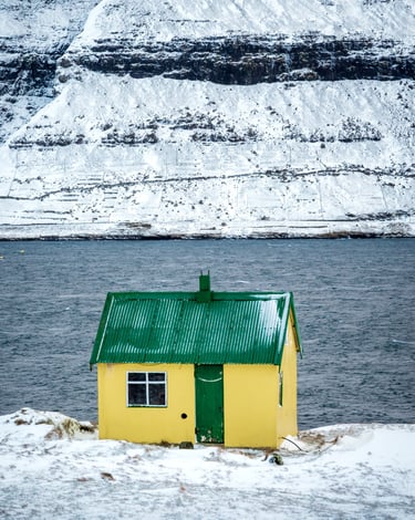 Snow-covered Faroese yellow house in winter — March photography workshop location