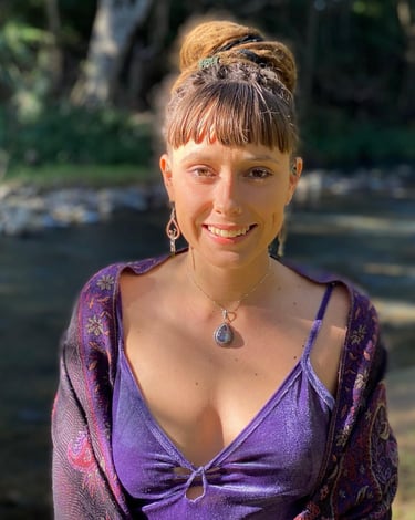 a woman in a purple dress with a necklace and earrings