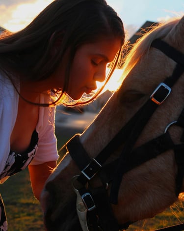 donna bacia in fronte un cavallo
