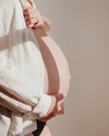 Femme enceinte tenant son ventre portant une chemise