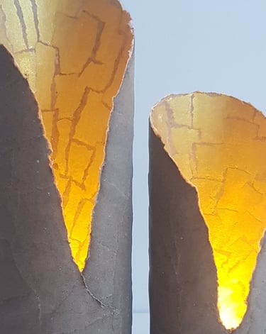 two candles with a candle in a concrete vase