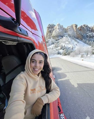 camionera sonriendo desde su camion en una de ;ps mejores paisajes de estados unidos