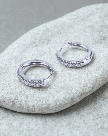 Par de aretes plateados con zirconias sobre una piedra