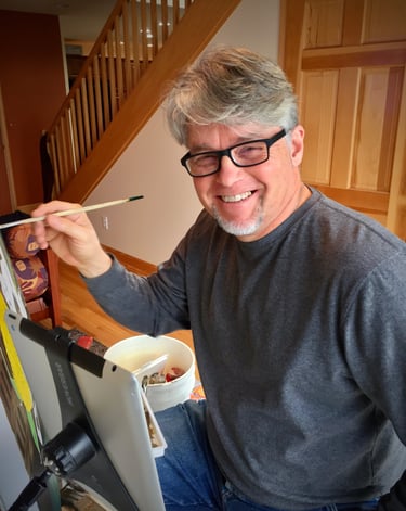 an artist smiling and holding a paintbrush