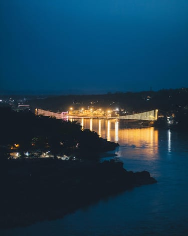 a bridge spanning a river with a bridge in the background