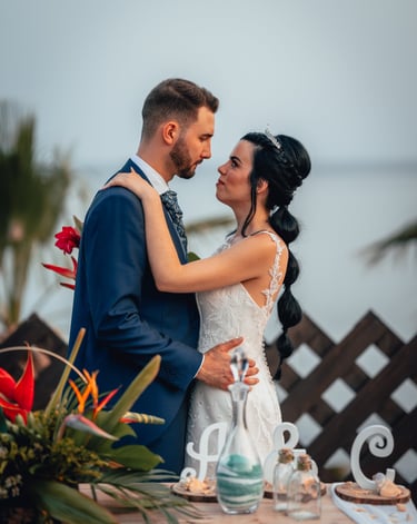 una novia y un novio en una playa abrazándose en el día de su boda