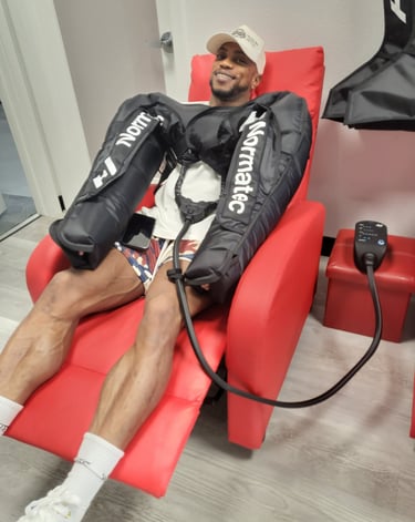 a man sitting in a chair with in an arm compression treatment