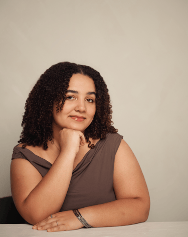 a woman with curly hair and a brown dress