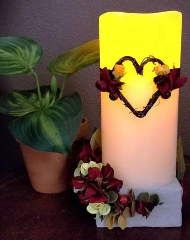 a candle with a heart and flowers