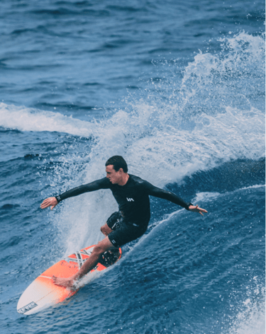 a man in a wetsuit surfing on a surfboard