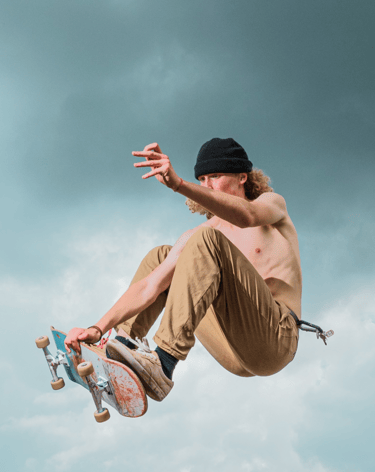 a man in a black hat and a skateboarder in mid air