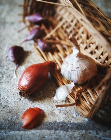 Photographie d'une corbeille en osier avec ail violet et échalotte