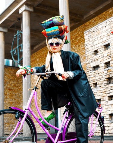 a woman in a hat and sunglasses is posing for a photo