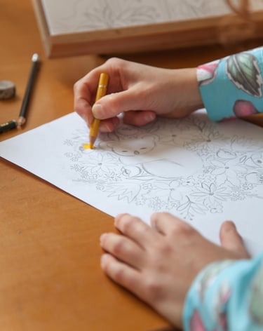 Hands making a koala illustration with colored pencils