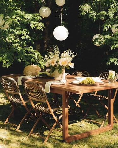 Garden seating area with wooden outdoor table, natural shade, green plants and relaxed dining setup