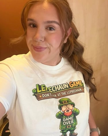 A smiling woman wearing a St. Patrick's Day Leprechaun Game graphic t-shirt.