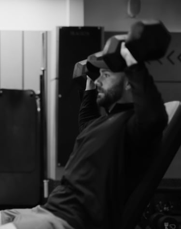 Trainer observing client’s seated dumbbell shoulder press in Leamington Spa gym, highlighting coaching and strength training.