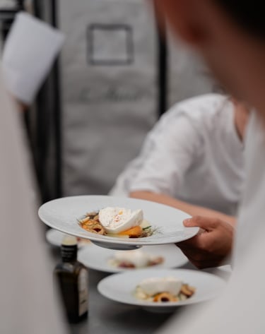 Assiette dressée tenue dans une main d'un cuisiner