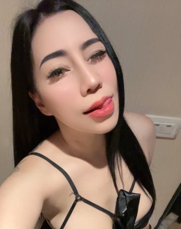 Lady wearing a black under garment and looking at the camera with her tongue out 