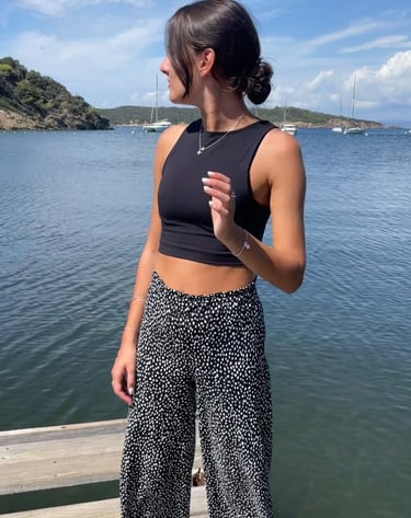 a woman standing on a dock with a black top