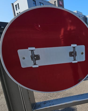 Détournement de panneaux de signalisation représentant un skateboard sur un sens interdit.