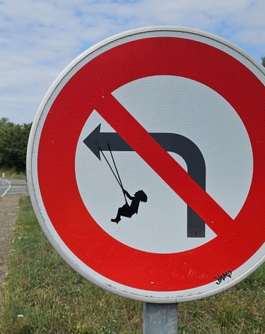 Street art sur panneau de signalisation représentant un fille sur une balançoire