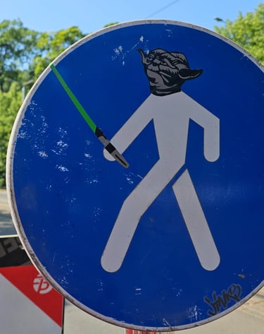 a street sign with a star wars lightsabed sticker on it