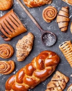 de nombreuses gourmandises sucrées et des ustensiles de cuisine sur un plan de travail
