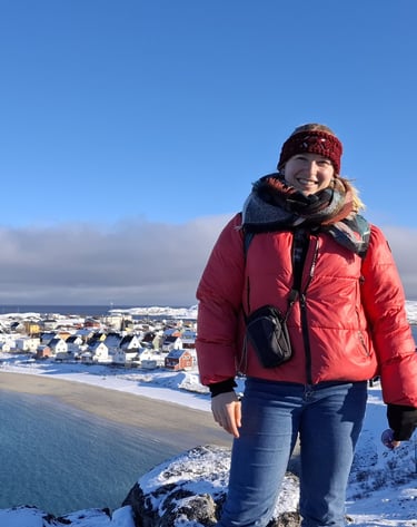 a woman standing in the arctic with a beautiful view