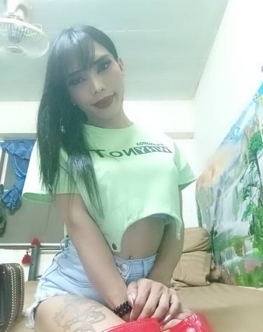 Ladyboy cropped green top and denim shorts with knee length red leather boots
